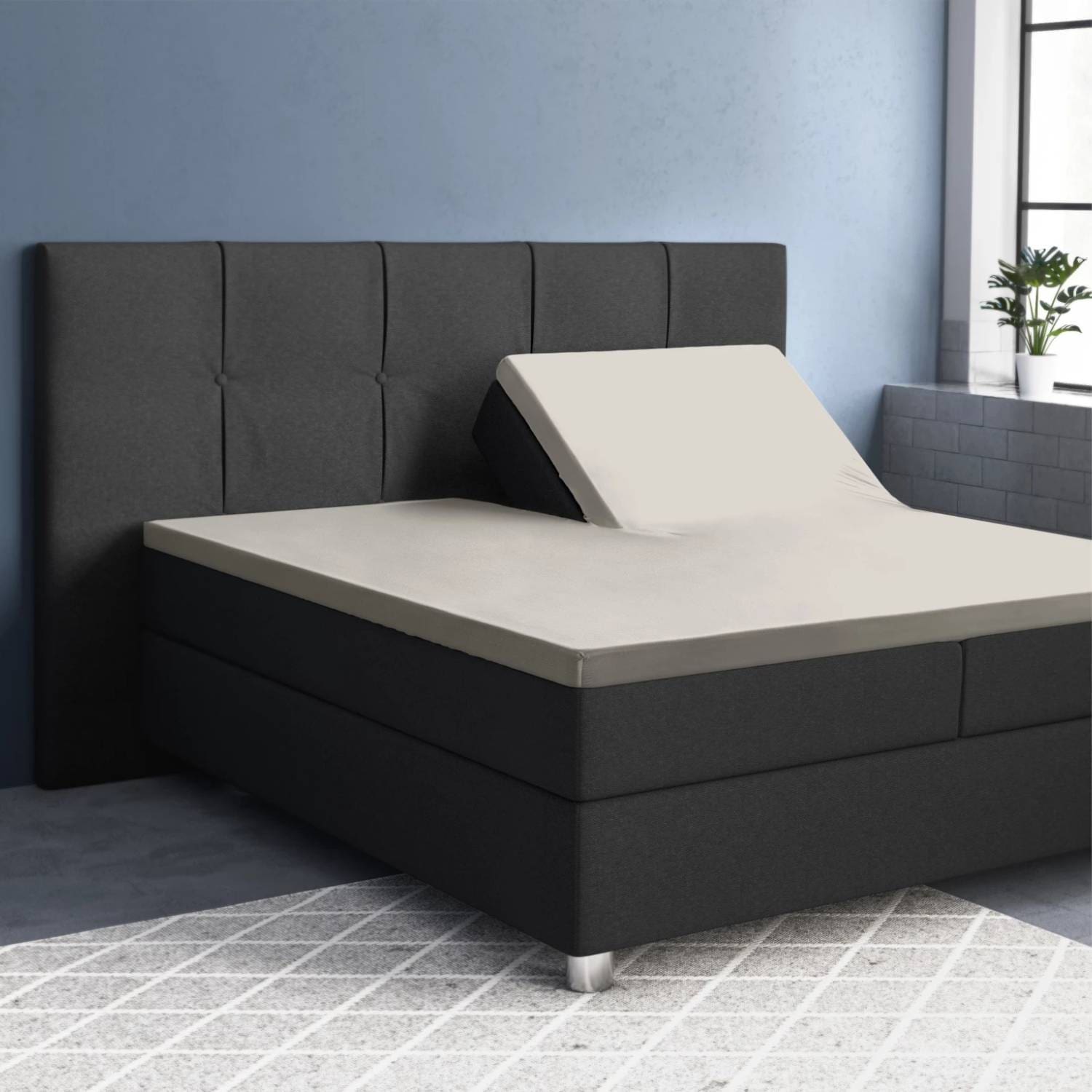 Verstelbaar bed in moderne slaapkamer met grijze bekleding.